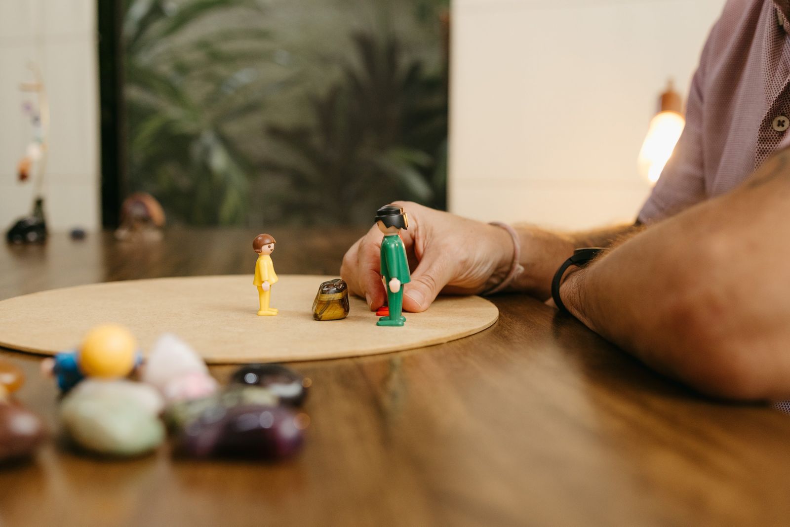 Constelação sendo aplicada com figuras representando pessoas e elementos sobre um tabuleiro
